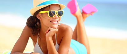 A woman smiling while lying on a beach